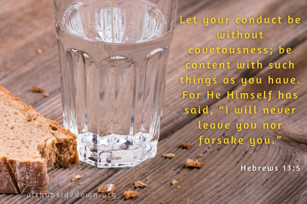 A glass of water on table with a crust of bread and Scripture verse Hebrews 13_5