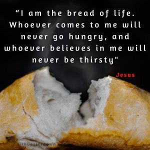 Broken fresh bread with the Scripture verse John 6:35